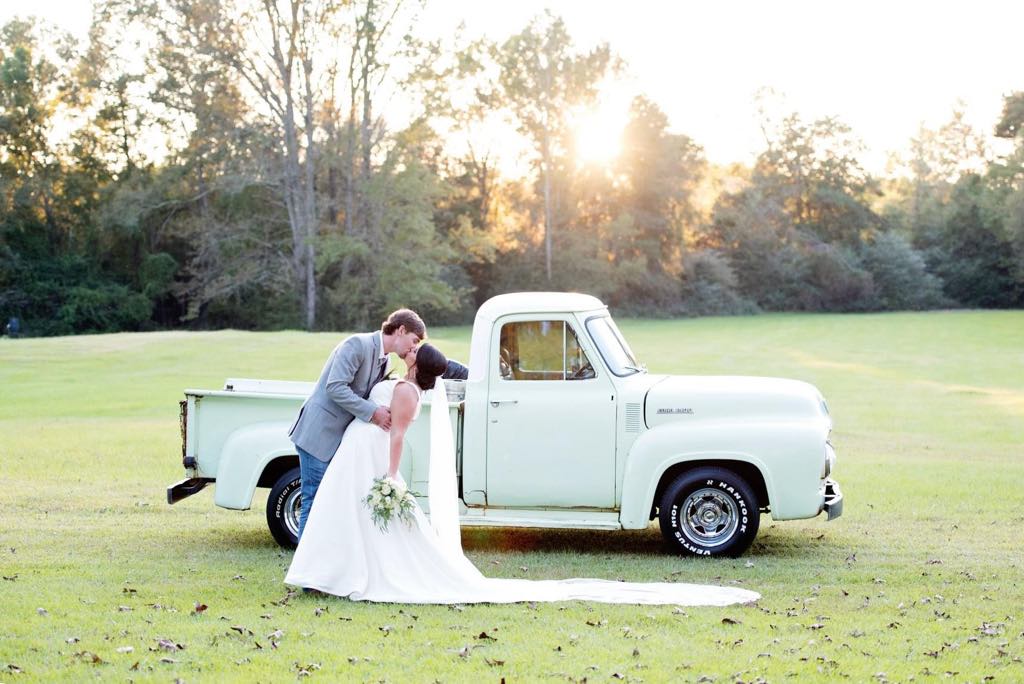 Bride and groom beside a vintage truck