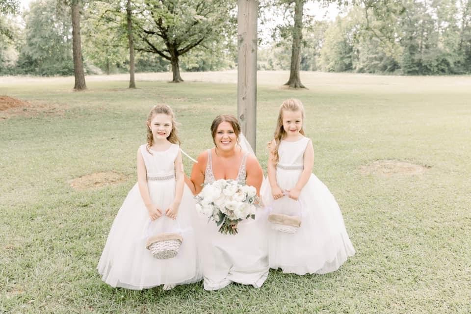 Bridesmaids in white dresses on the lawn